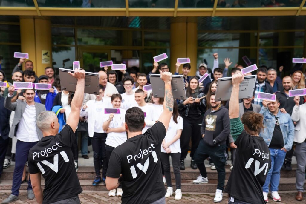 O gașcă de copii fericiți, afară, pe scările școlii, cu mâinile în aer și mândrindu-se cu diplomele primite.