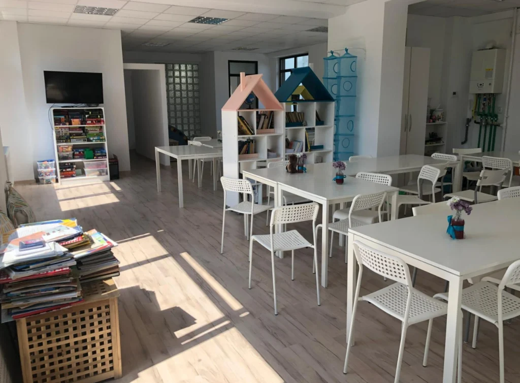 Una dintre sălile luminoase din interiorul SAGA Kid, amenajată cu mese și scaune pentru lucru individual și în echipă.